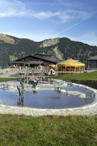 a park with a pool of water in front of a building at Erlebnis-Restaurant & Berghotel Rossweid in Sörenberg