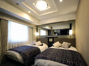 Postel nebo postele na pokoji v ubytování APA Hotel Ueno Inaricho Ekikita