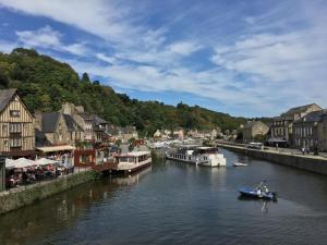 a small boat in a river in a town at La Petite Madeleine is a Charming 2 Bedroom Pet Friendly Gite situated on Dinan Port in Dinan
