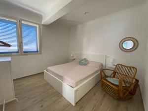 una camera da letto con un letto, una sedia e una finestra di Gemma Mediterranea a Campomarino