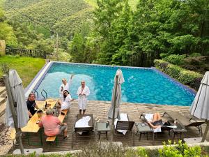 a group of people standing next to a swimming pool at Moganshan Arcadia Resorts in Deqing