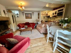 a living room with a red couch and a table at La Petite Madeleine is a Charming 2 Bedroom Pet Friendly Gite situated on Dinan Port in Dinan +31 photos