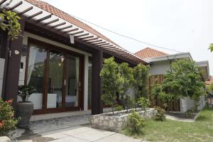 a house with glass doors and trees in a yard at Gita Bali House in Nusa Dua