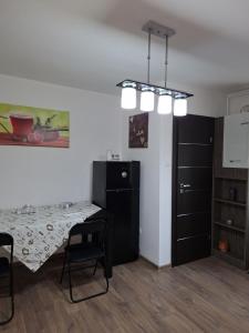 a room with a table and a refrigerator and a table and chairs at Promenade apartment in Târgu-Mureş +3 photos