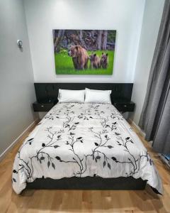 a bedroom with a bed and a painting on the wall at LuxQuarters Huckleberry Suite in Kitimat