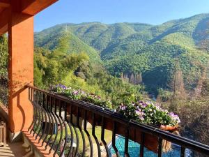 a balcony with flowers and a view of a mountain at Moganshan Arcadia Resorts in Deqing