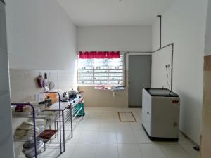 a white kitchen with a refrigerator and a window at Homestay NAQ D' Kuala Kangsar in Kuala Kangsar