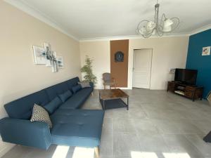 a living room with a blue couch and a tv at Gite 12 personnes in Digny