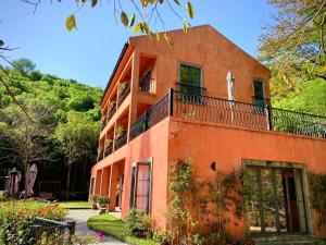 an orange building with a balcony on top of it at Moganshan Arcadia Resorts in Deqing