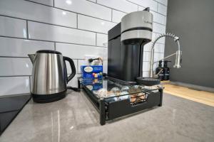 a kitchen counter with a coffee pot and a tray of food at LuxQuarters Blueberry Studio in Kitimat