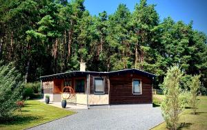 a small cabin in a park with trees in the background at Ferienhaus am Dachsberg in Bad Saarow