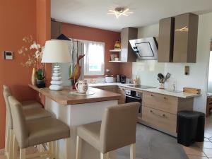 a kitchen with orange walls and a table and chairs at Villa Palmera - Classée 3 étoiles - Grand confort, calme, et magnifique vue dégagée in Canet