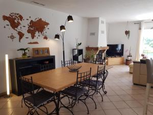 a dining room with a wooden table and chairs at Villa Palmera - Classée 3 étoiles - Grand confort, calme, et magnifique vue dégagée in Canet