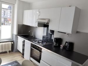 a kitchen with white cabinets and a stove top oven at L'échappée belle de Normandie in Saint-James