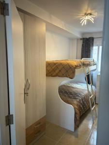 2 literas en una habitación pequeña con puerta en Apt Kandinsky Mallorca, en S'Illot