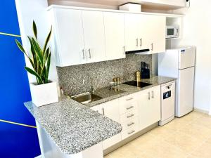 a kitchen with white cabinets and a sink at Apt Kandinsky Mallorca in S'Illot
