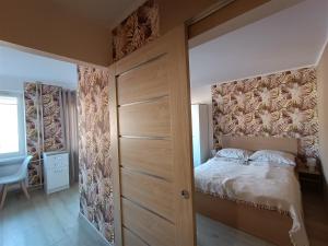 a bedroom with a bed with a wooden door at Apartament w Srebrnym Mieście in Tarnowskie Góry