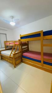 Uma ou mais camas em beliche em um quarto em Apartamento com varanda Gourmet na praia da enseada