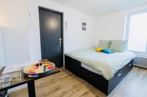a small bedroom with a bed and a table at Le Cocoon, studio centre, wifi, stationnement in Cognac