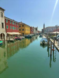 a canal in a city with boats and buildings at Luxury Apartments Riva Vena in Chioggia