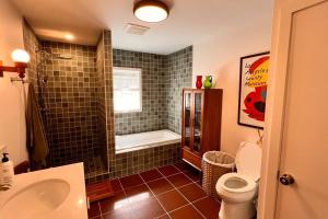 a bathroom with a shower and a toilet and a sink at The Mod Cabin in Bearsville +26 photos