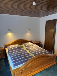 a bedroom with a wooden bed with blue sheets at Pension Thilo in Bad Wildbad