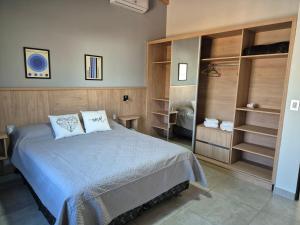 a bedroom with a bed and some open shelves at Apart Elisa in Villa Elisa +7 photos