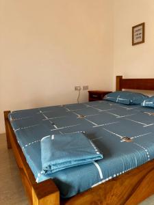 a bed with blue sheets and blue pillows on it at paje zanzibar apartment in Paje