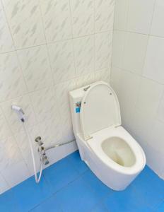 a white toilet in a bathroom with a blue floor at paje zanzibar apartment in Paje