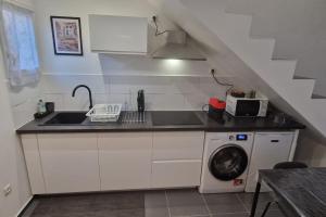 a kitchen with a sink and a washing machine at Résidence ROZ 1 in Massy