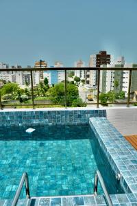 a swimming pool with a view of a city at Feel Home - Flat Sofisticado Próximo a Praia in Cabedelo
