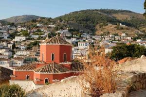 Cheerful 2-bedroom villa with gorgeous terraces في هيدرا: اطلالة على مدينة يوجد بها مبنى على تلة