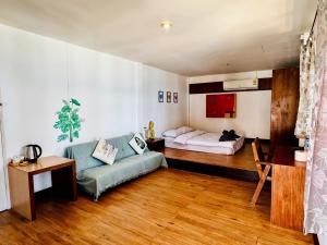 a bedroom with a bed and a couch in a room at A Little Bungalows By Beach in Mae Nam