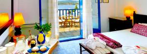 Schlafzimmer mit einem Bett und Blick auf einen Balkon in der Unterkunft Agionissi Resort in Amolianí