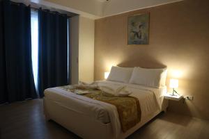 a bedroom with a large bed with a window at Hotel Casa Ilustre in Balayan