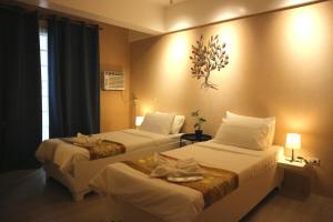 a hotel room with two beds and a window at Hotel Casa Ilustre in Balayan