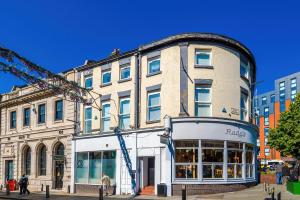un edificio con una grúa delante de él en The Seven Suites Liverpool, en Liverpool