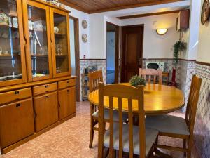 a kitchen with a wooden table and a dining room at Encanto de Xisto in Piódão