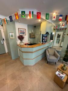 a restaurant with a counter and a chair and flags at Hôtel Flor Rivoli in Paris