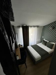 a small bedroom with a bed and a window at Hôtel Flor Rivoli in Paris