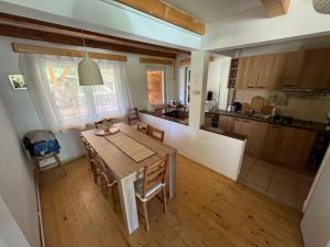 a kitchen and dining room with a table and chairs at Vacation House Lunca Bradului in Lunca Bradului +22 photos