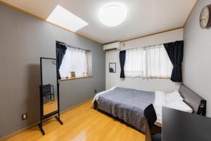 a bedroom with a bed and a mirror at NOT A HOME亀有 駅徒歩5分 無料駐車場 ディズニーまで車22分 羽田空行バス直通 90m2 in Tokyo +24 photos