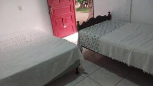 two beds in a room with a red door at Guadalupe Herrera in Tola
