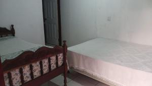 two twin beds in a bedroom with a door at Guadalupe Herrera in Tola