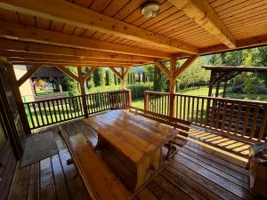 a wooden porch with a wooden table on a deck at Vacation House Lunca Bradului in Lunca Bradului