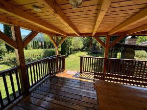 a wooden deck with awning on a house at Mountain Cabin Retreat - Terrace, BBQ, Hot Tub in Lunca Bradului