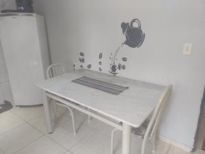a white table in a kitchen with a table and chairs at Apto n.09 condominio custo beneficio. in Brasília