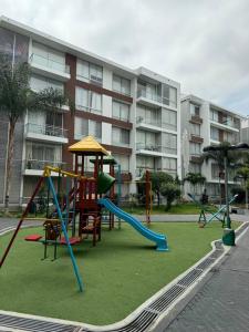 a playground in front of a apartment building at Confortable departamento Piura in Piura +15 photos