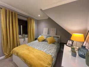 a bedroom with a bed with yellow sheets and yellow pillows at Two Bedroom Flat in London in London