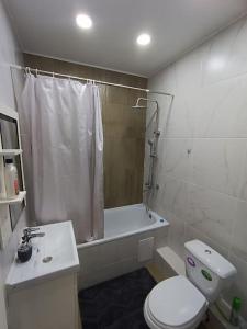 a bathroom with a toilet and a shower and a sink at Уютная квартира в парковой зоне in Chong-Aryk